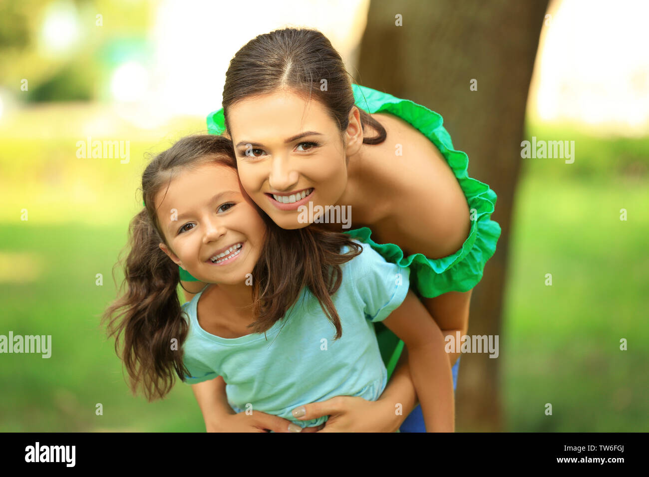 Cute little girl with mother in park on sunny day Stock Photo - Alamy