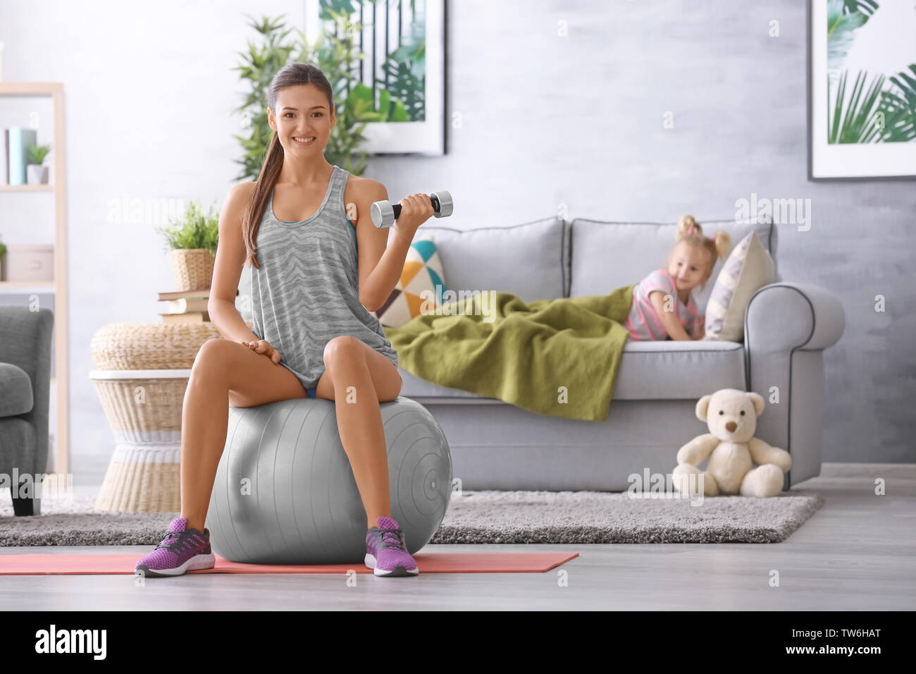 Beautiful young woman training at home Stock Photo - Alamy