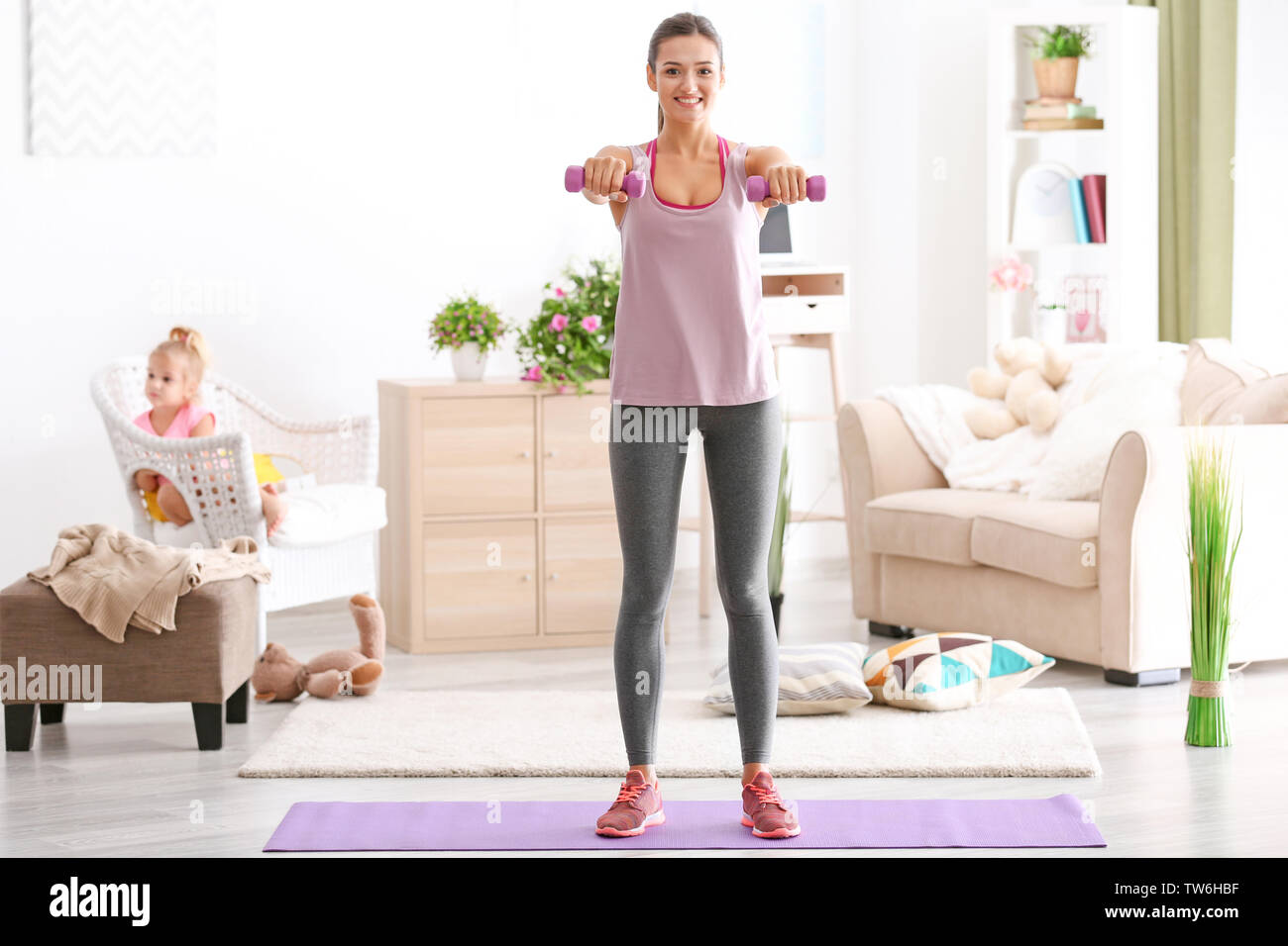 Beautiful young woman training at home Stock Photo - Alamy