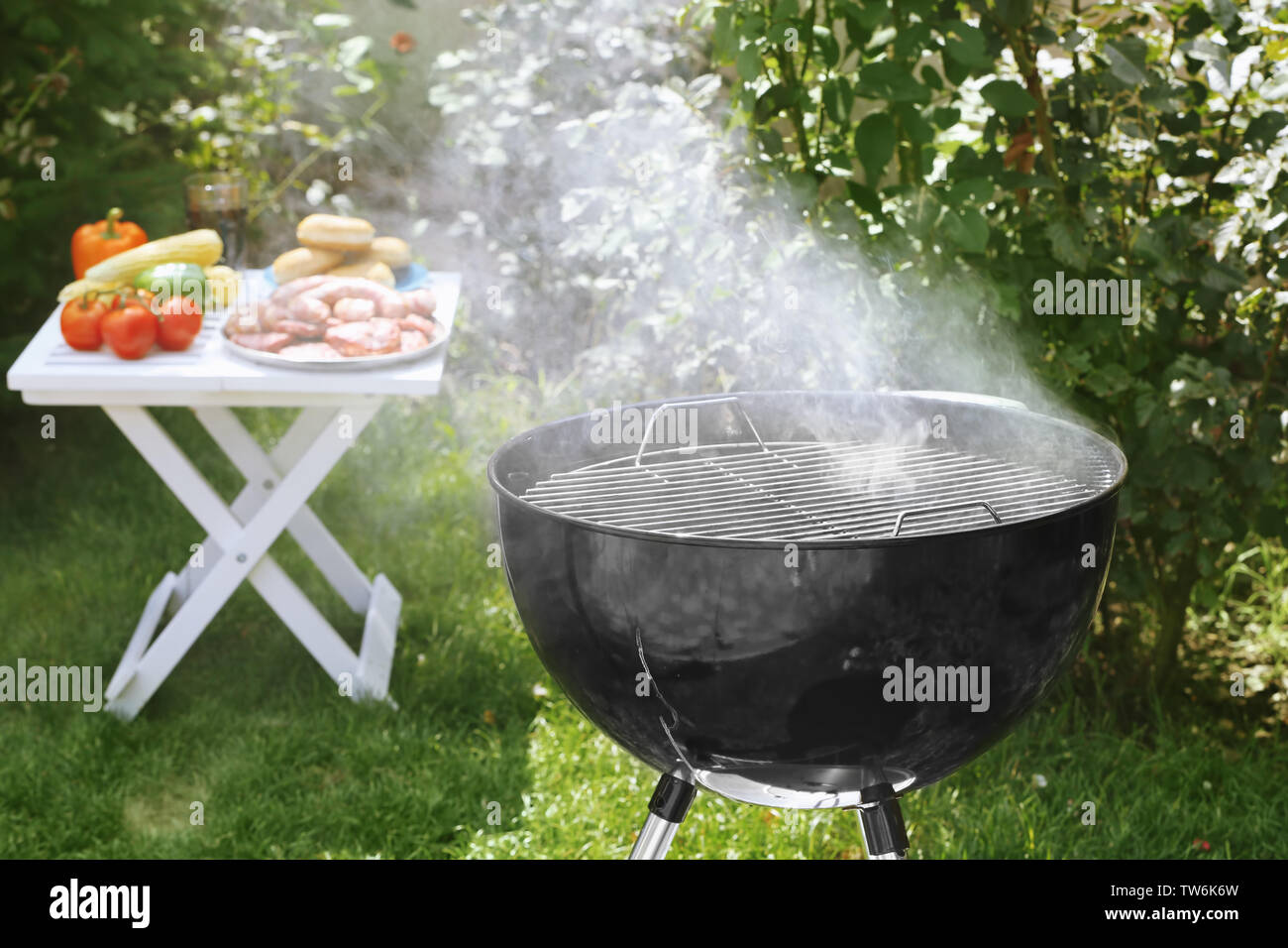 Barbecue grill with smoke on backyard Stock Photo - Alamy