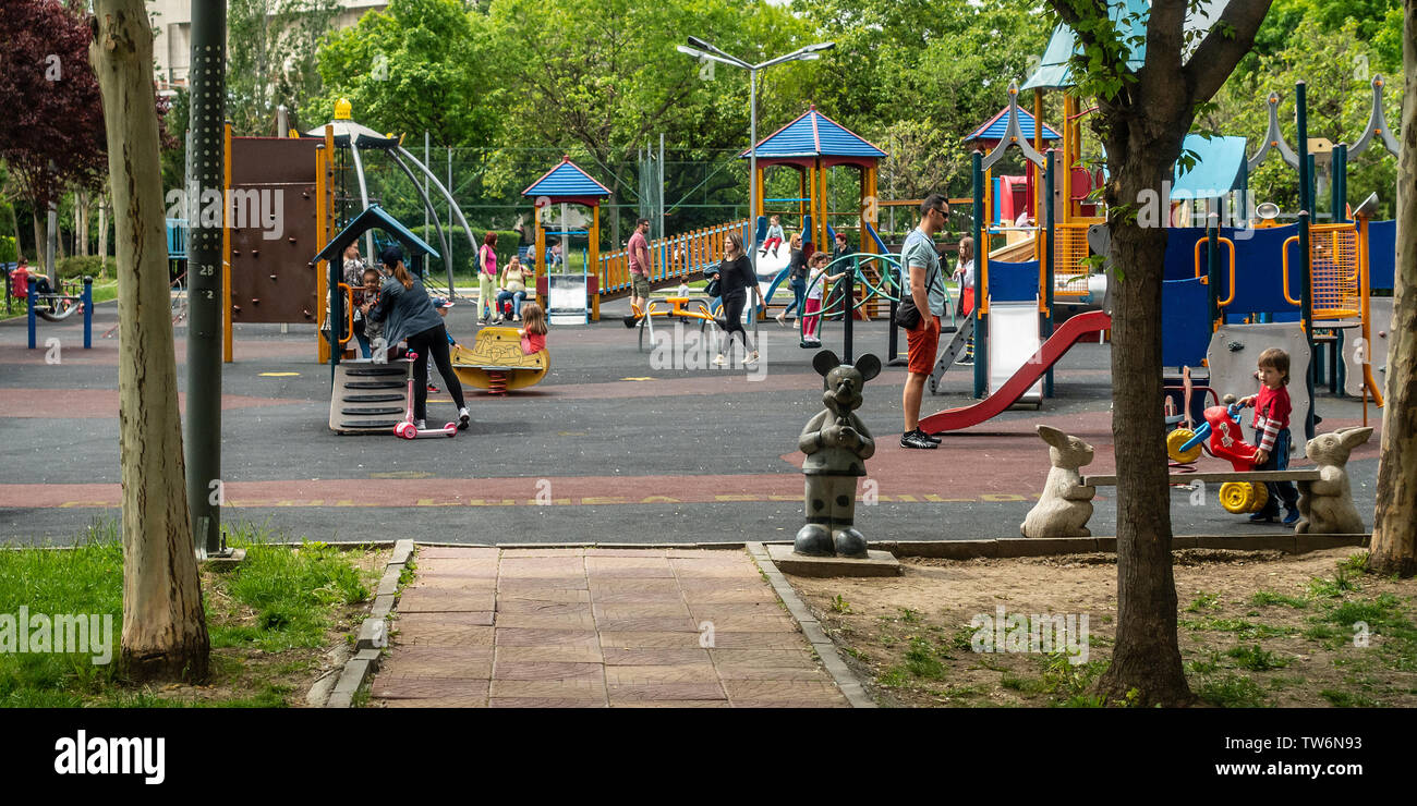 Familes enjoying playing in one of the playgrounds for children in the Parcul Lumea Copiilor, (Children's World Park) in central Bucharest, Romania. Stock Photo
