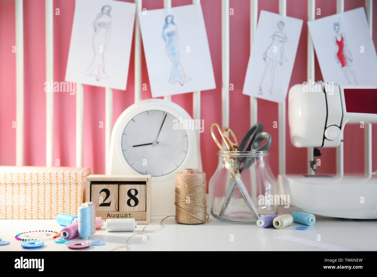 Sewing accessories and machine on table in workshop Stock Photo