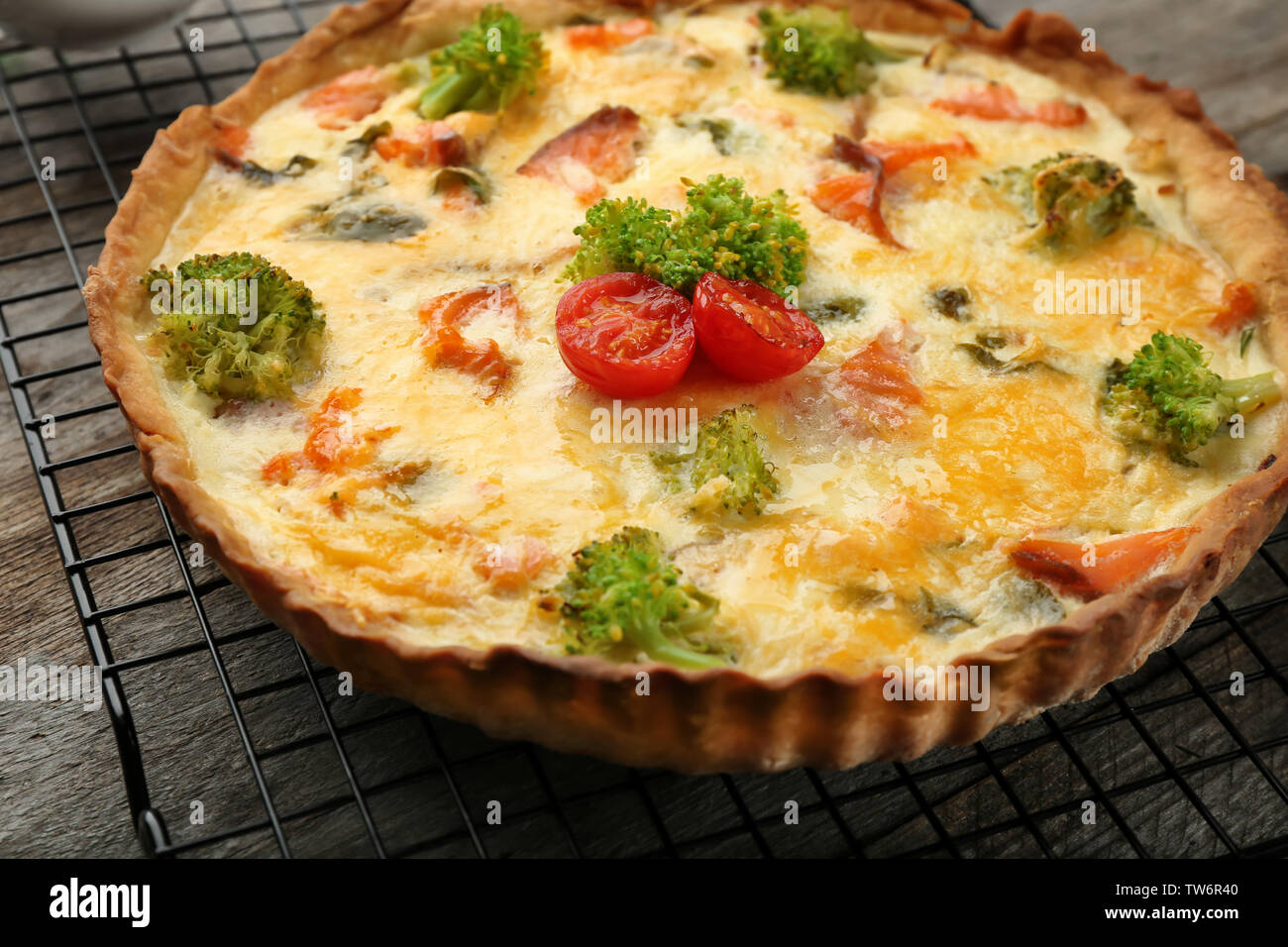 Tasty salmon quiche on cooling rack Stock Photo