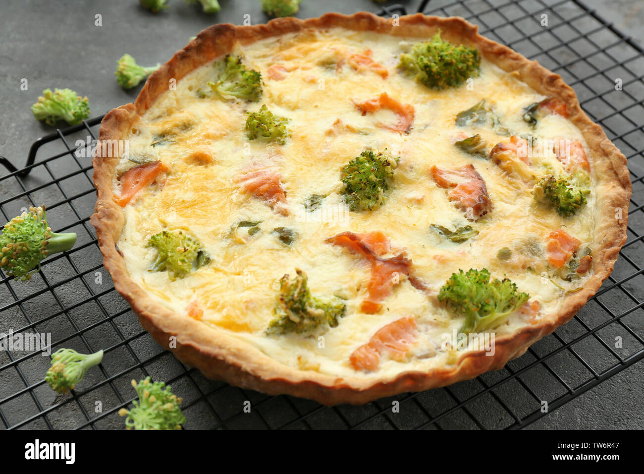 Tasty salmon quiche on cooling rack Stock Photo