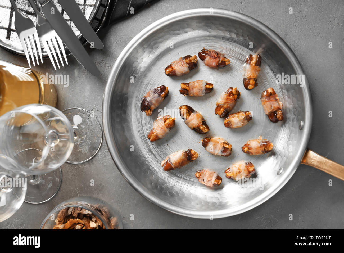 Bacon wrapped dates in frying pan Stock Photo Alamy