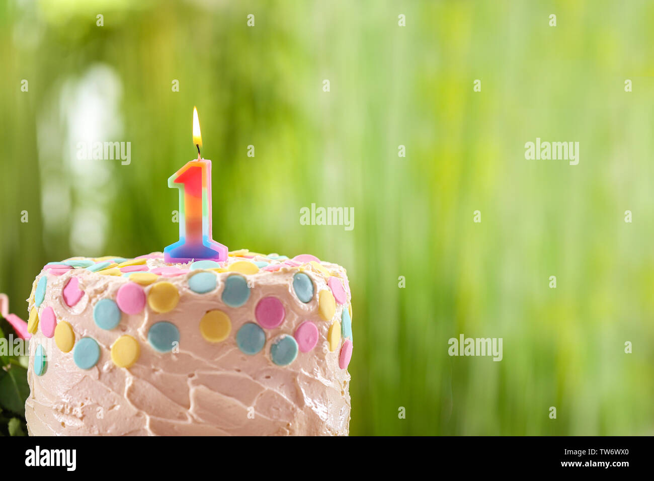 Cake with candle for first birthday on blurred background Stock Photo ...
