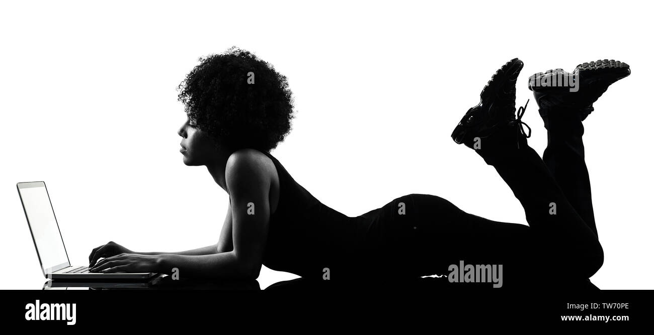 one mixed race african young teenager girl woman computer laptop in studio shadow silhouette isolated on white background Stock Photo