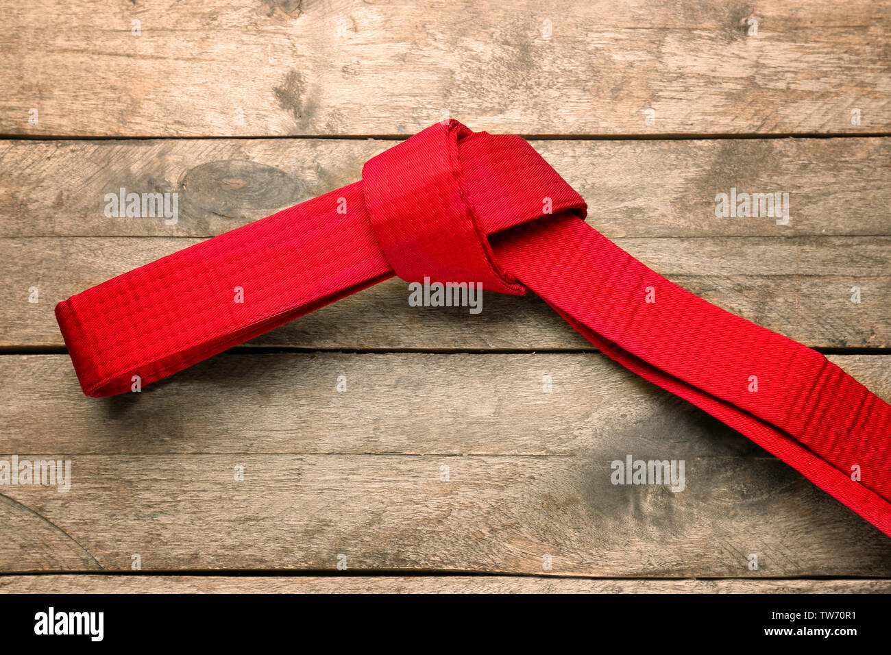 Red karate belt on wooden background Stock Photo - Alamy