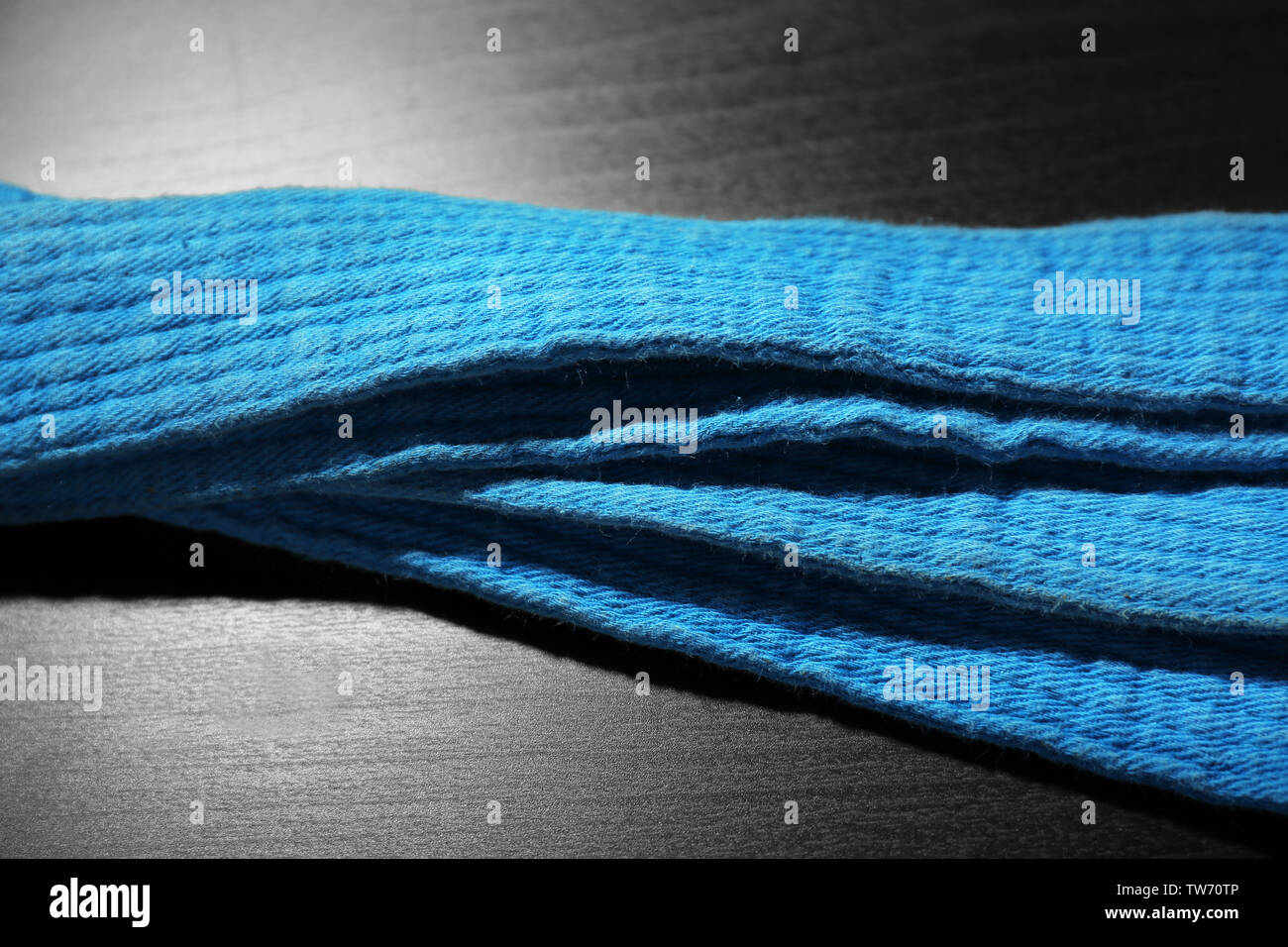 Blue karate belt on dark background Stock Photo - Alamy