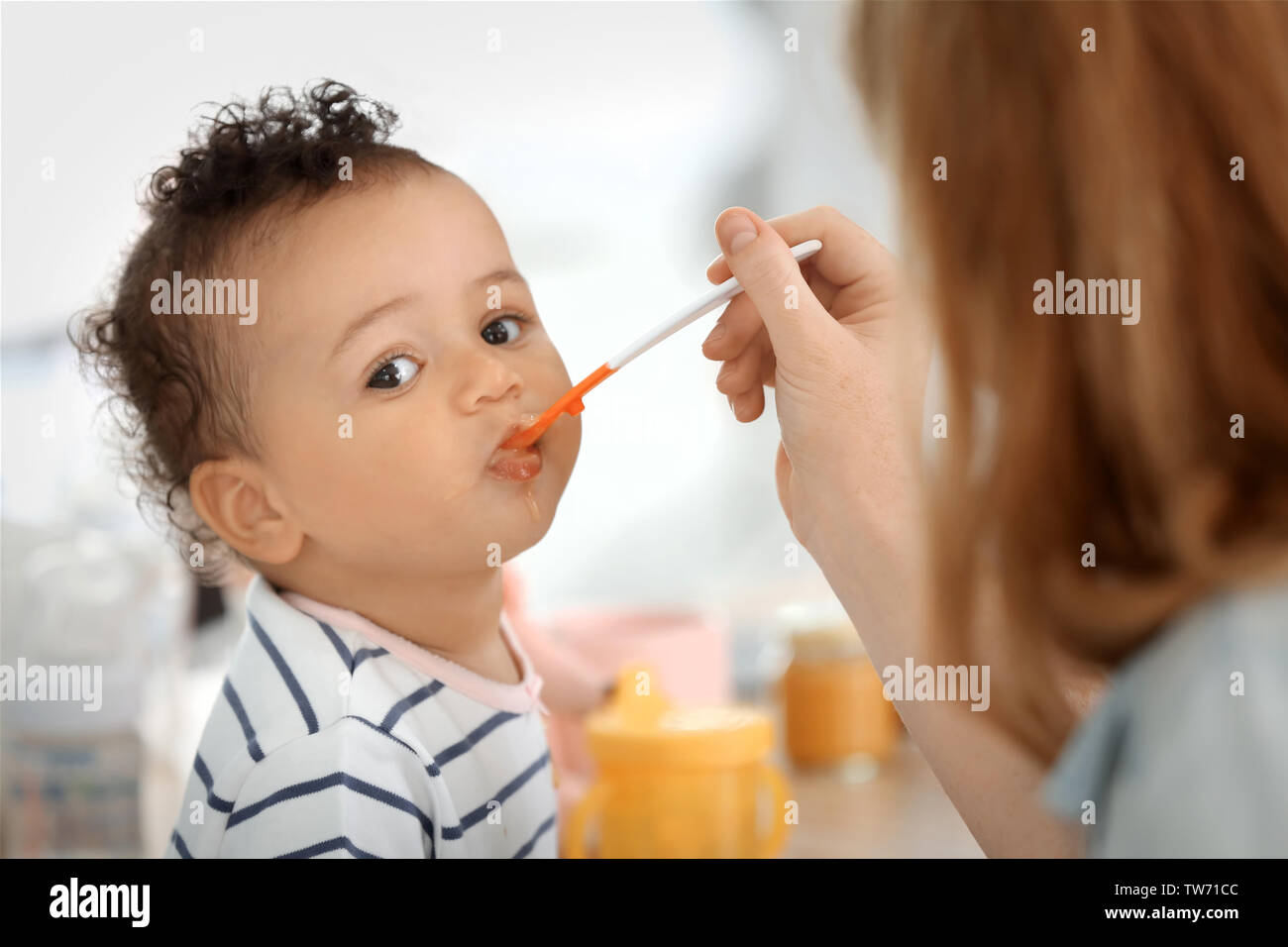 Black mother spoon feeding child hi-res stock photography and images - Alamy