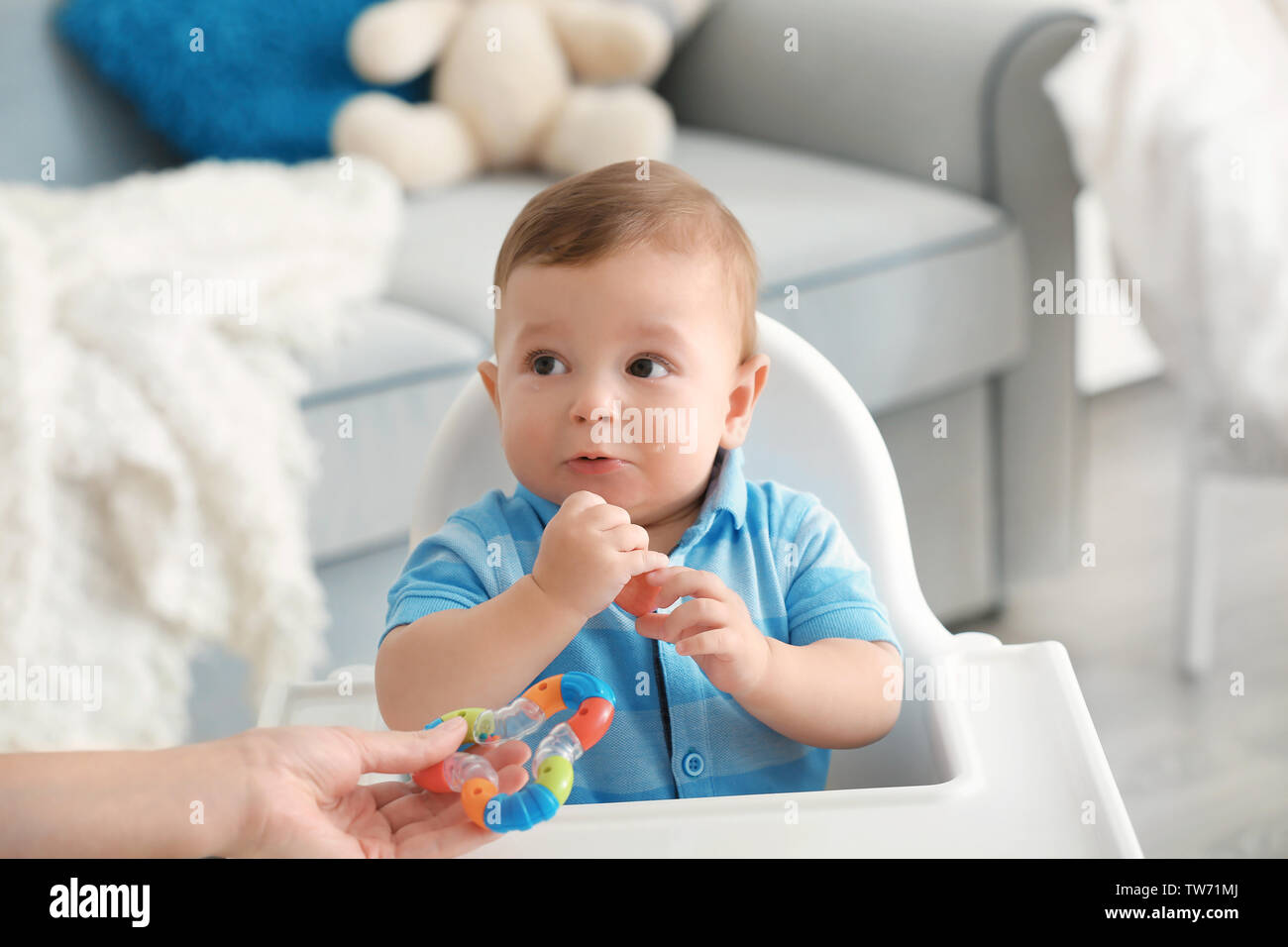 Kids Using Rattle Mother giving rattle to baby indoors Stock Photo - Alamy