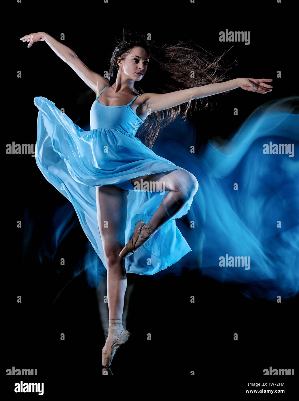 one caucasian young woman ballet dancer dancing isolated on black background with  light painting motion blur speed effect Stock Photo