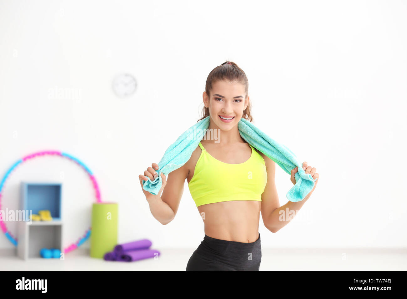 Young sporty woman with towel in gym Stock Photo - Alamy