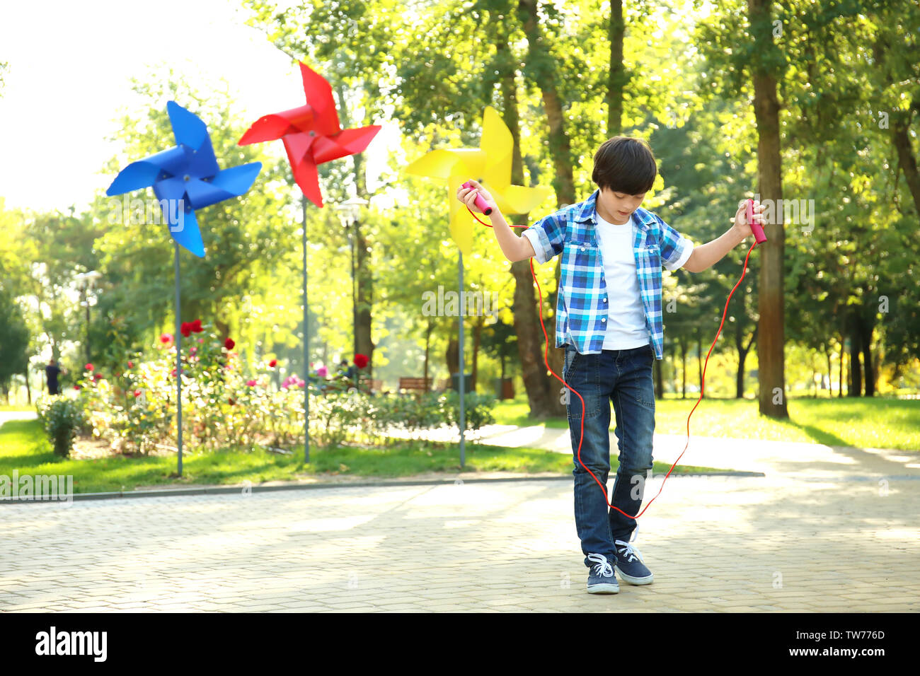 Cute little boy jumping rope in park Stock Photo - Alamy