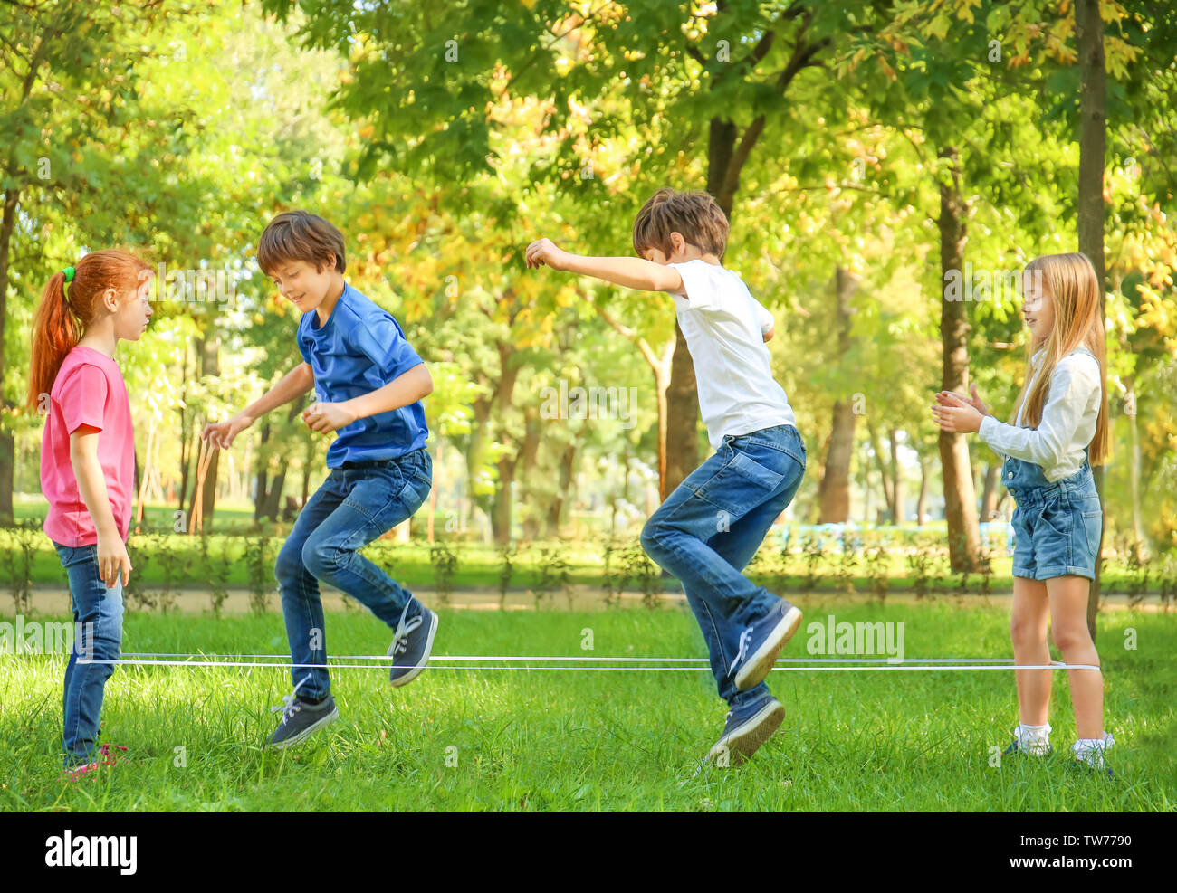 Cute little children jumping rope in park Stock Photo - Alamy