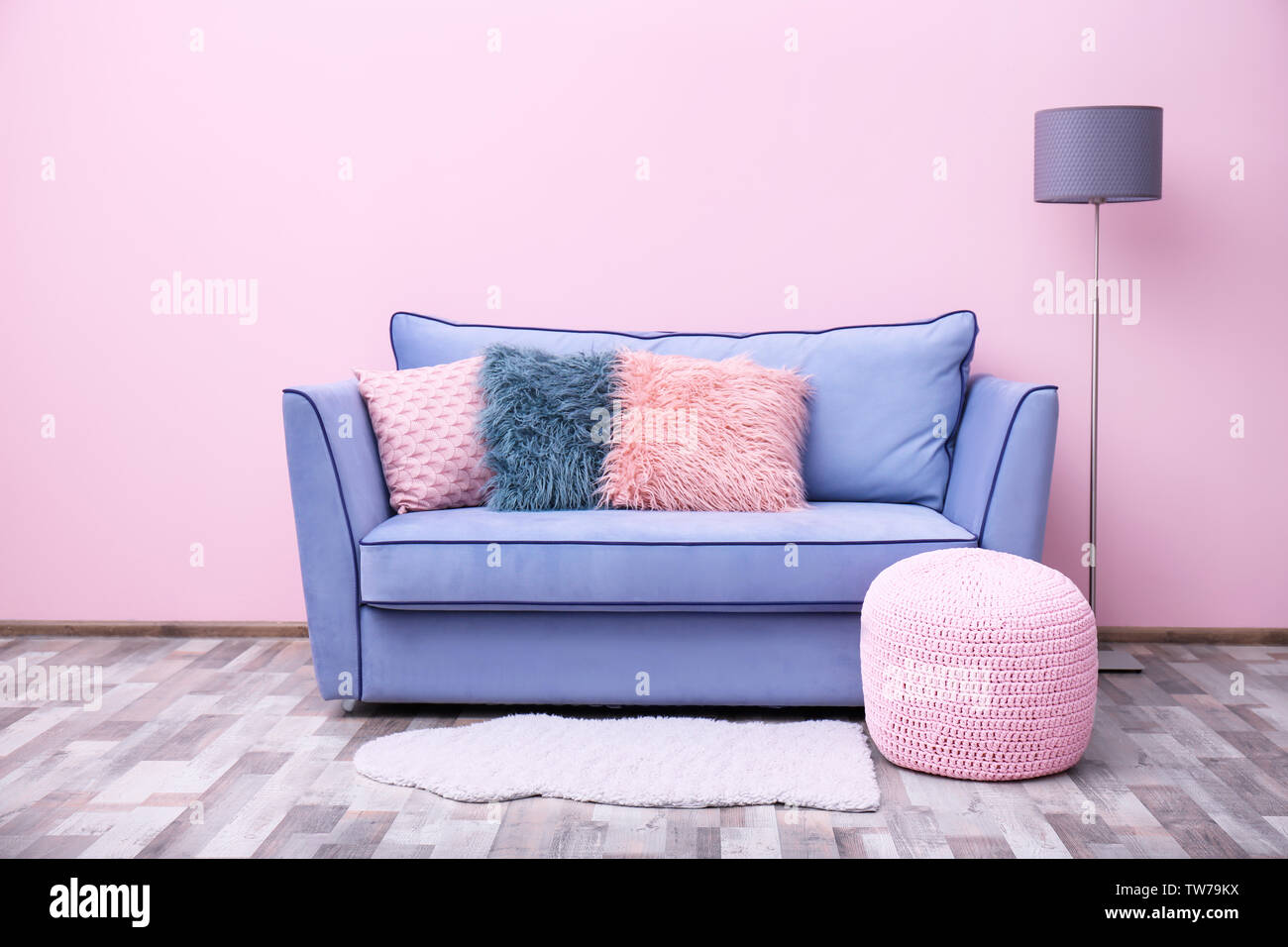 Comfortable sofa against pink wall indoors Stock Photo Alamy