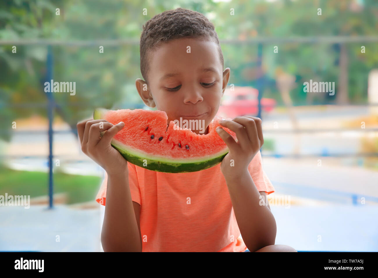 Cute African American boy eating watermelon at home Stock Photo Alamy