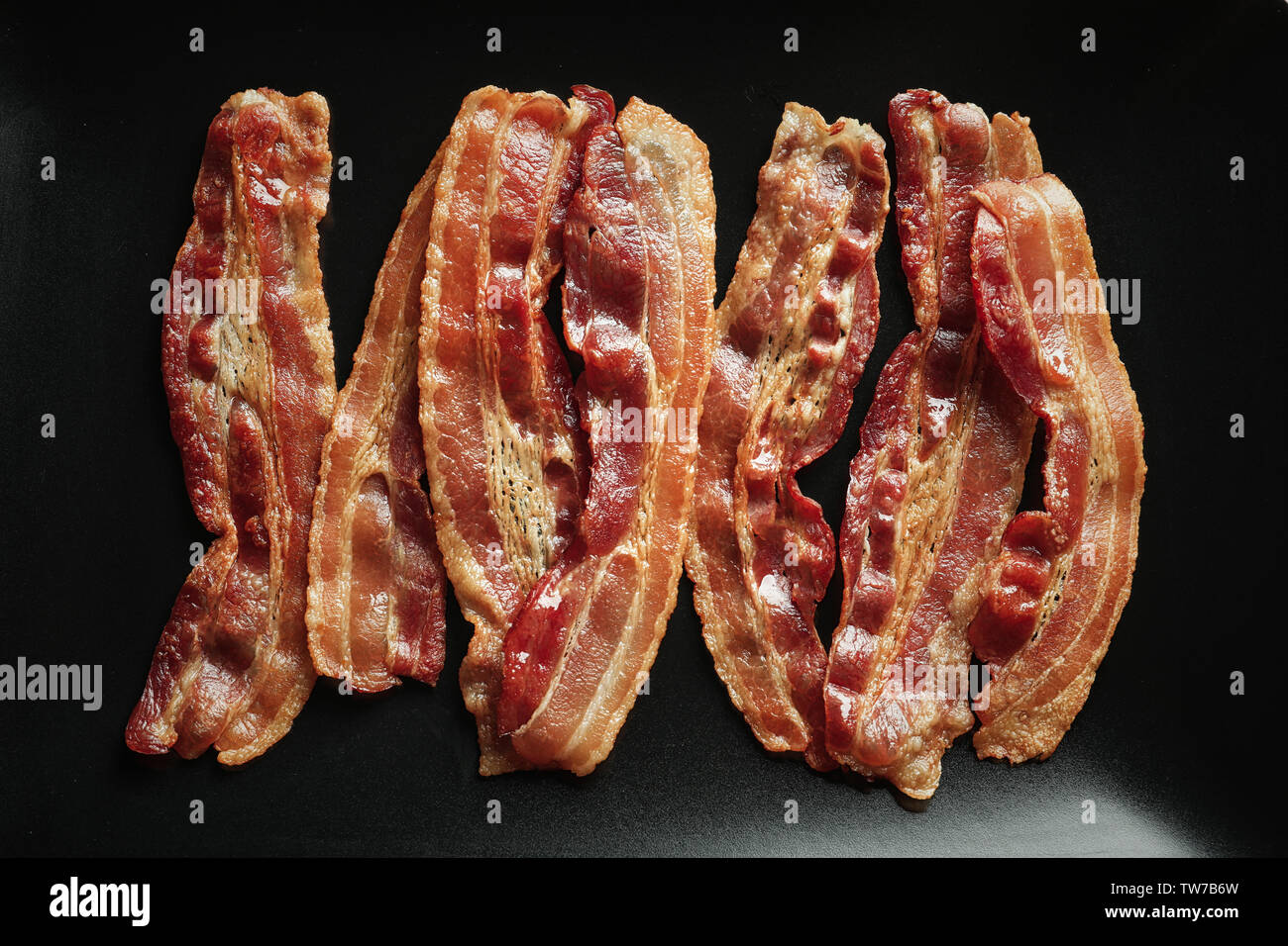Cooked bacon rashers on plate, closeup Stock Photo - Alamy