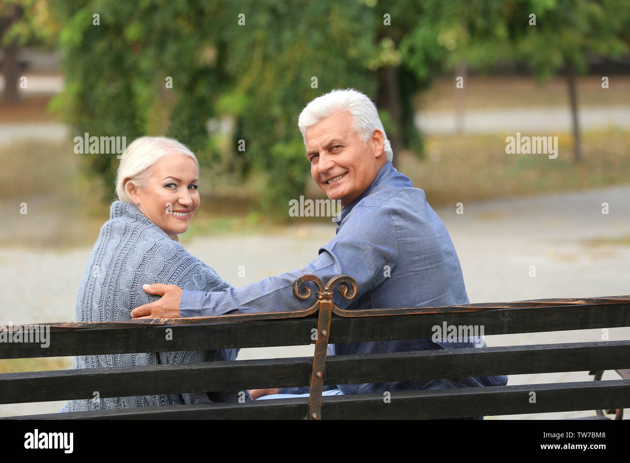 Mature couple sitting on bench outdoors Stock Photo - Alamy