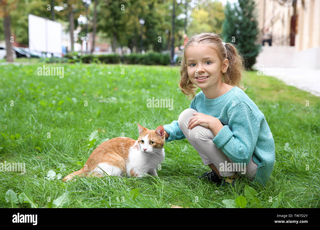 Cute little girl with cat outdoors Stock Photo - Alamy