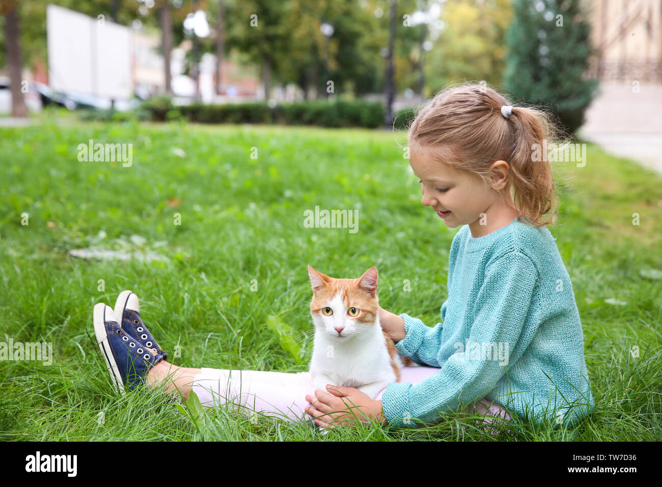 Cute little girl with cat outdoors Stock Photo - Alamy