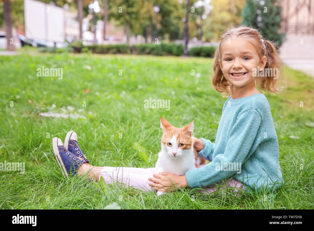 Cute little girl with cat outdoors Stock Photo - Alamy