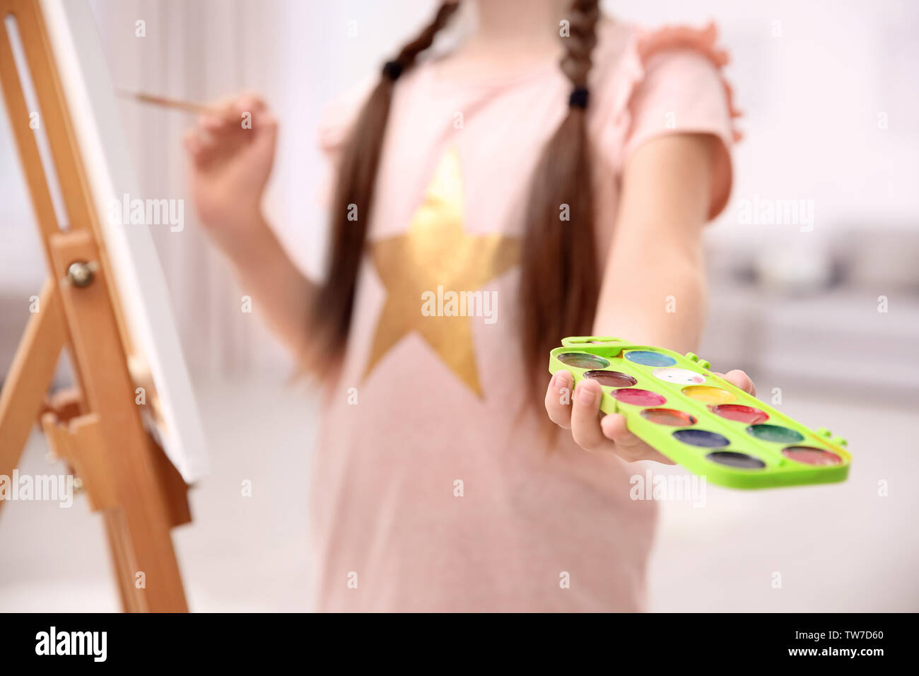 Little girl holding paint palette indoors Stock Photo - Alamy