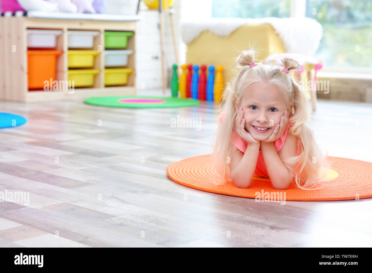 Cute little girl lying on floor at home Stock Photo Alamy