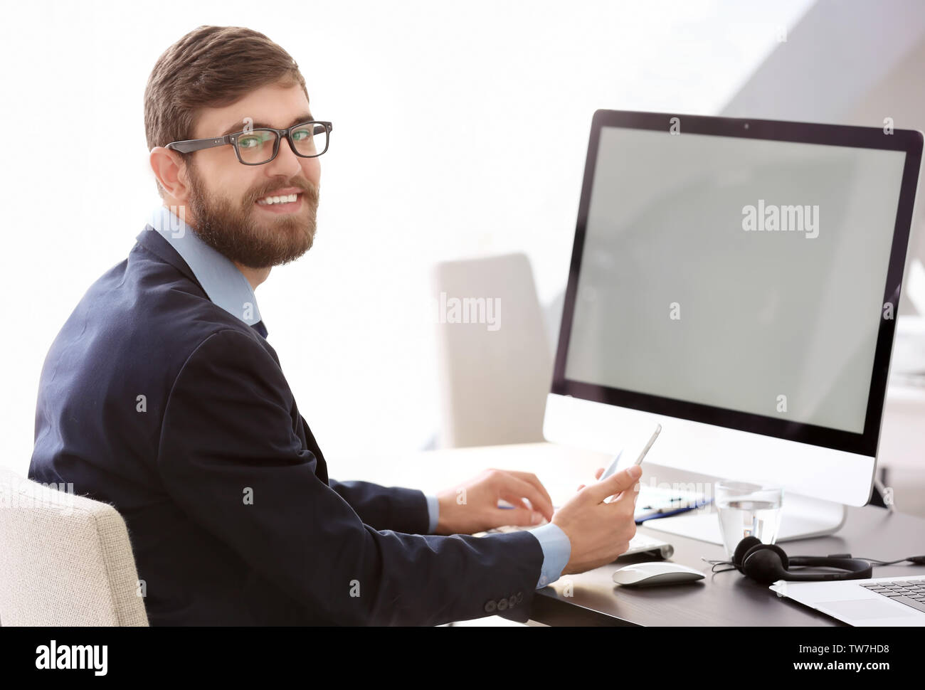Manager using mobile phone while working in office Stock Photo