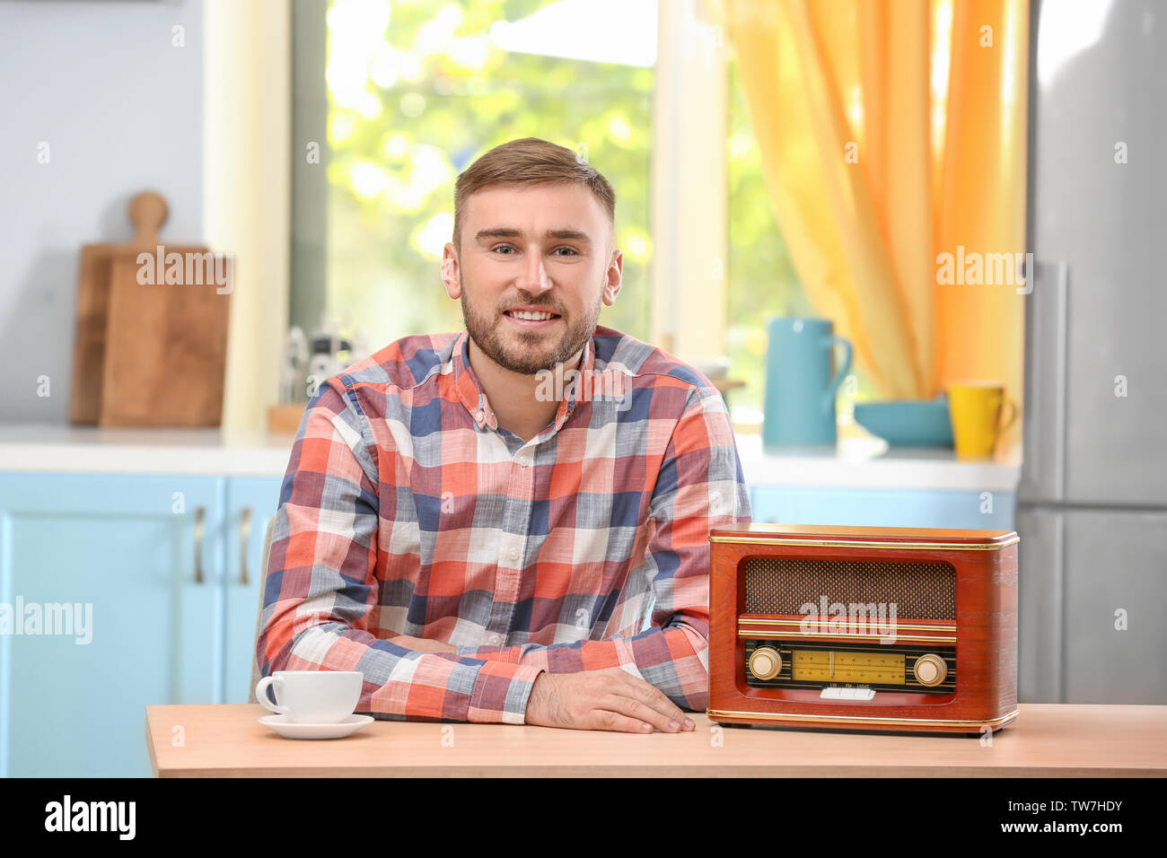 Young man listening to radio in kitchen Stock Photo - Alamy