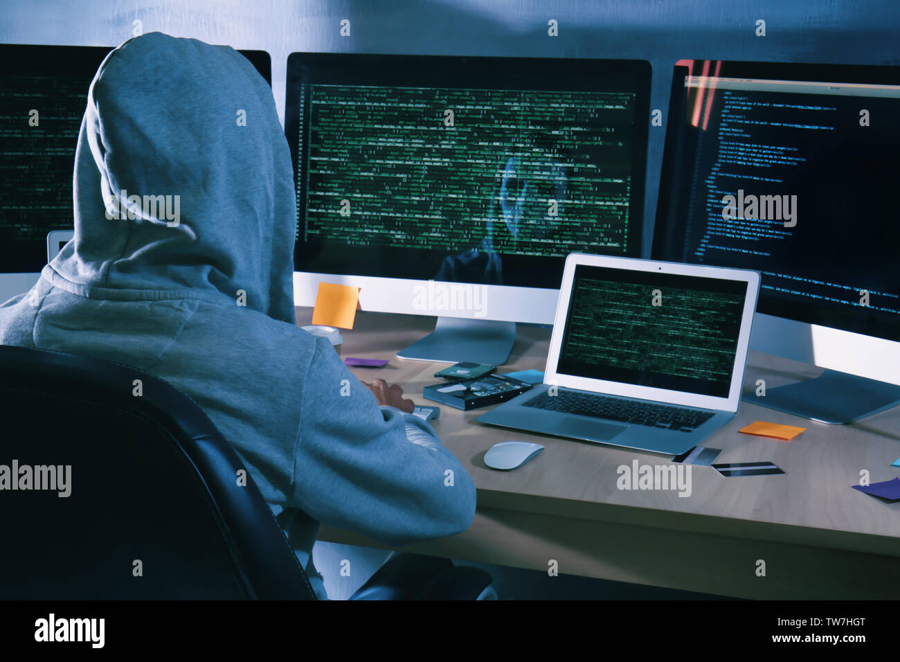 Man wearing hoodie hacking server in dark room Stock Photo - Alamy