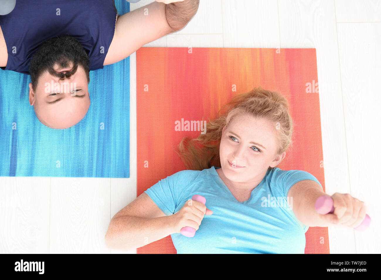 Overweight couple doing exercises at home Stock Photo