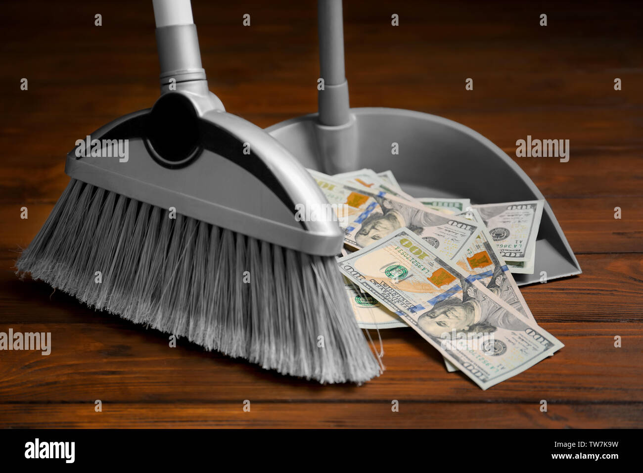 Broom sweeping dollars into dustpan Stock Photo Alamy