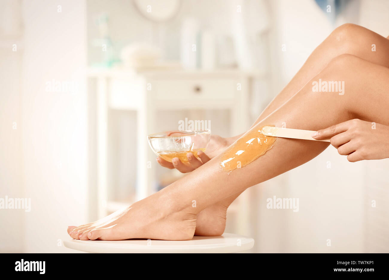 Beautiful woman epilating her legs in bathroom Stock Photo Alamy