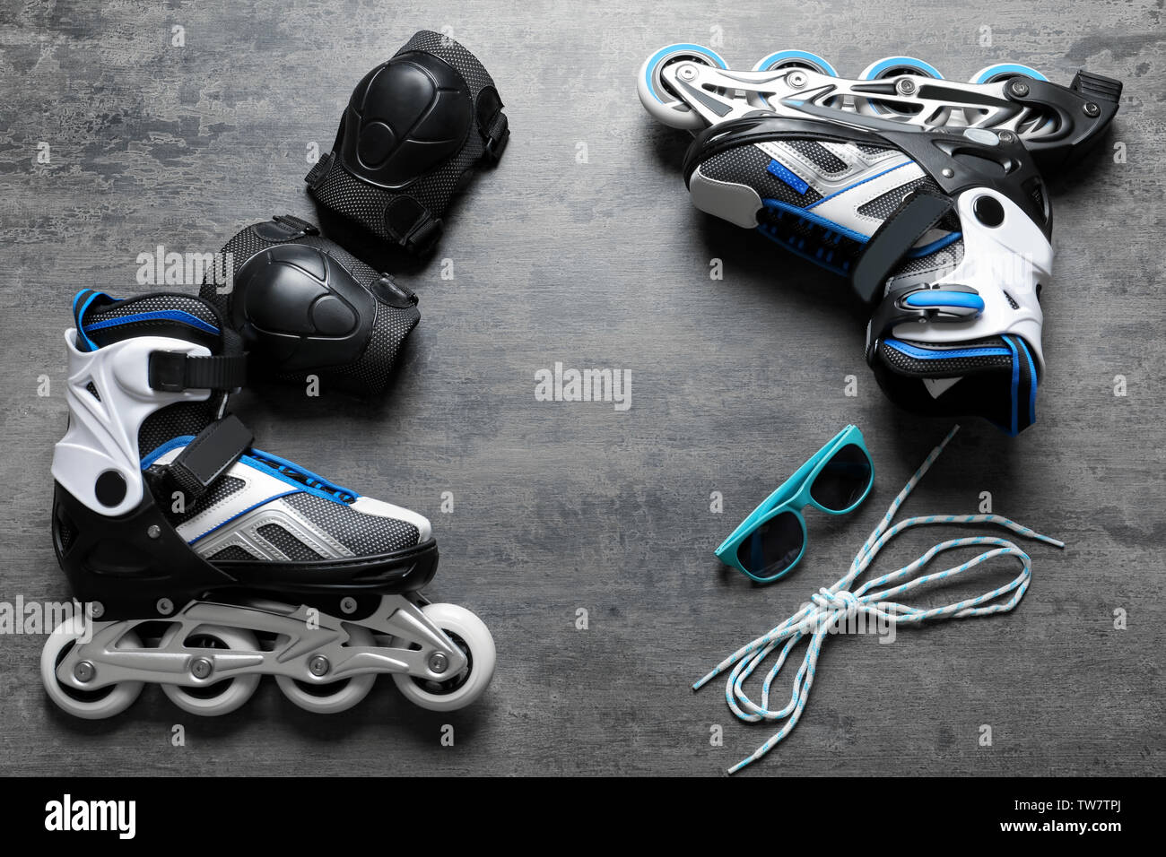 Roller skates, knee pads and sunglasses on grey background Stock Photo