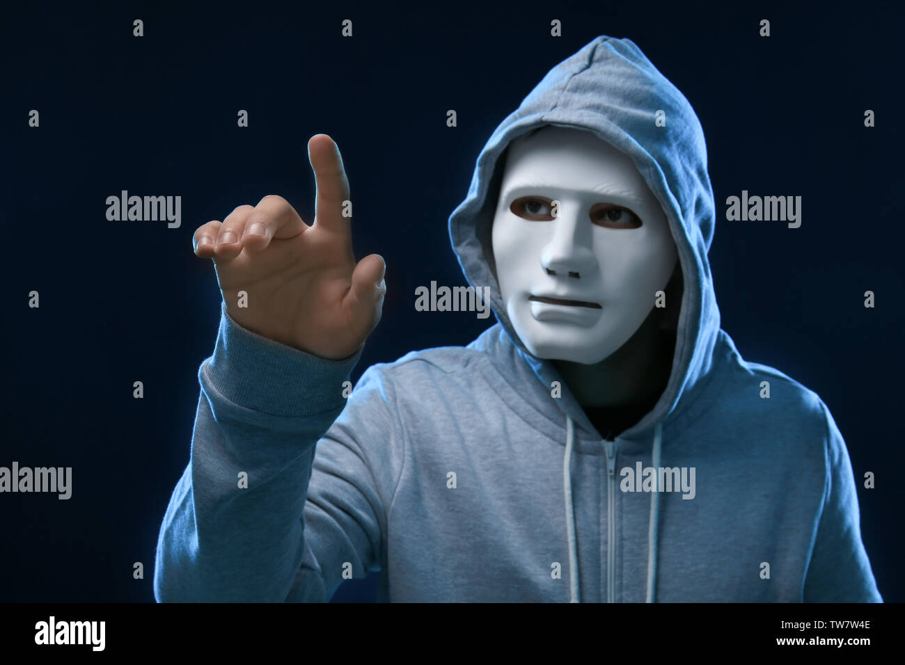 Hacker in mask on dark background Stock Photo