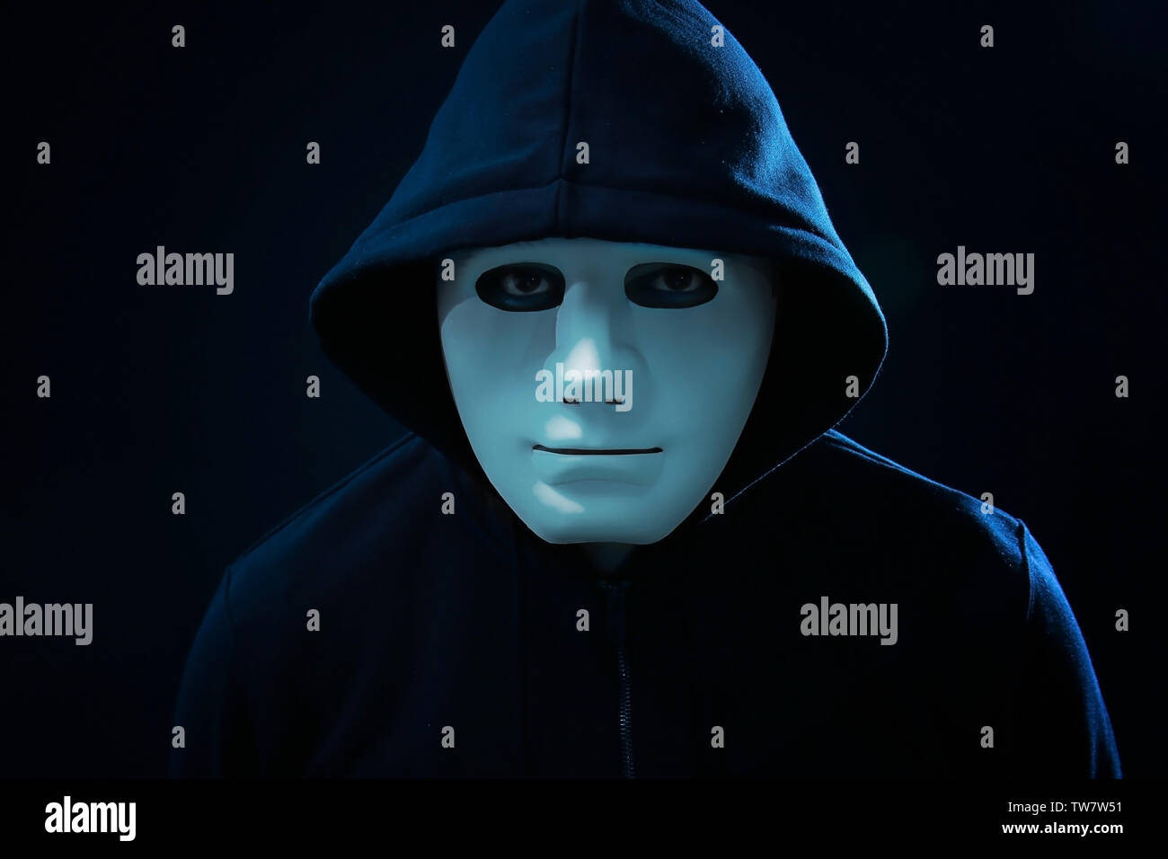 Hacker in mask on dark background Stock Photo