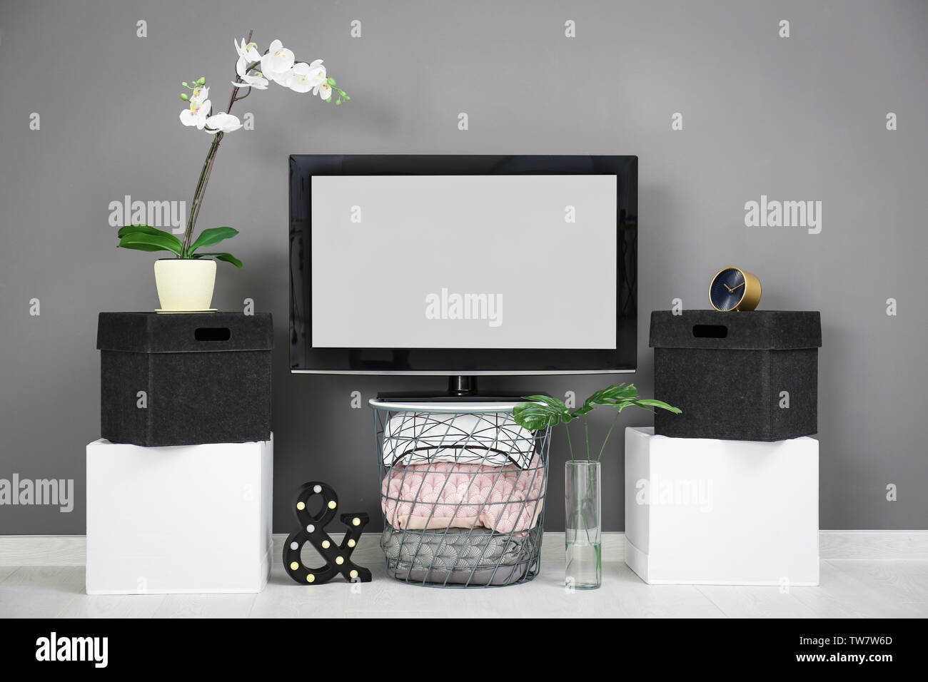 Modern TV on stand against grey wall background Stock Photo Alamy