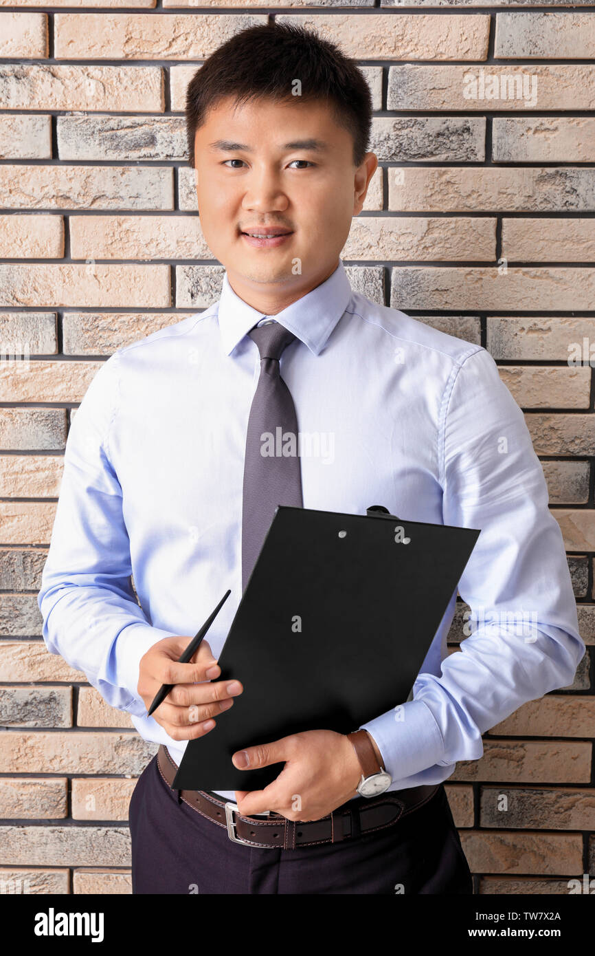 Young manager on brick wall background Stock Photo