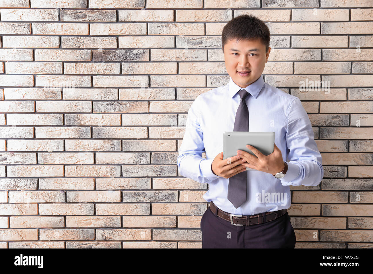 Young manager on brick wall background Stock Photo