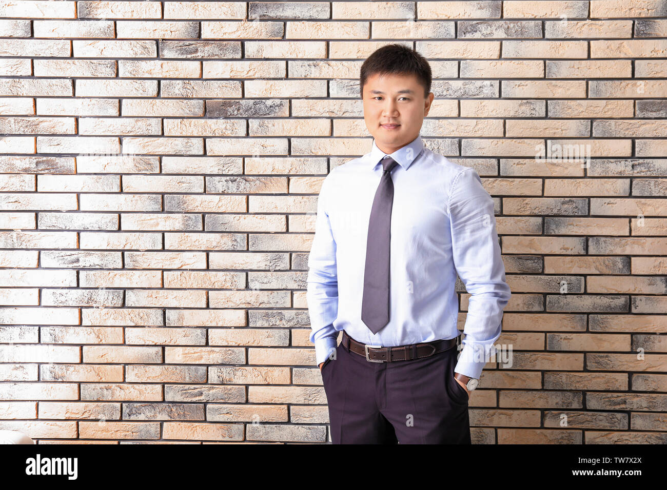 Young manager on brick wall background Stock Photo