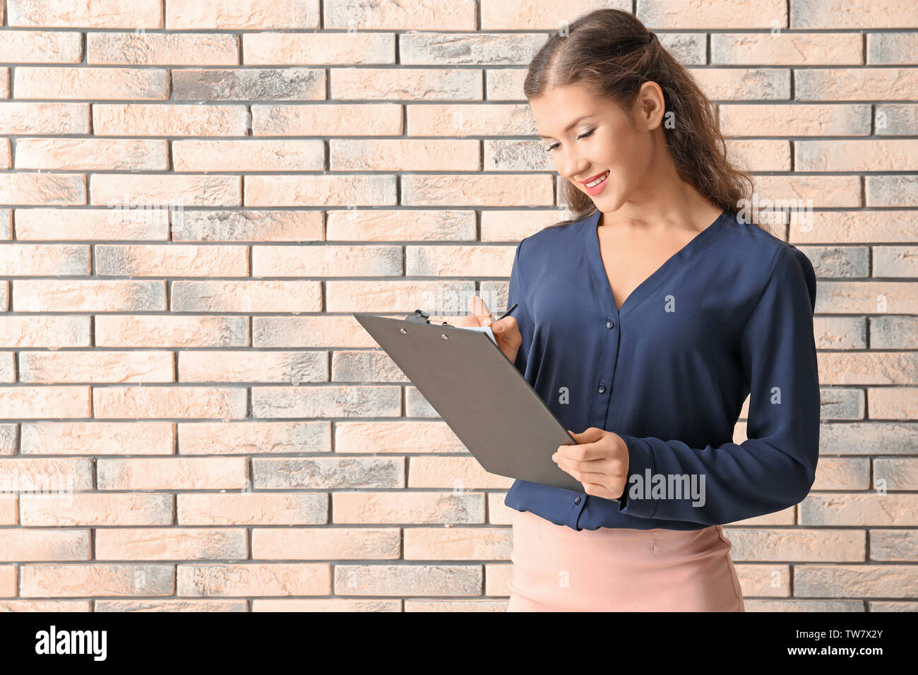Young manager on brick wall background Stock Photo
