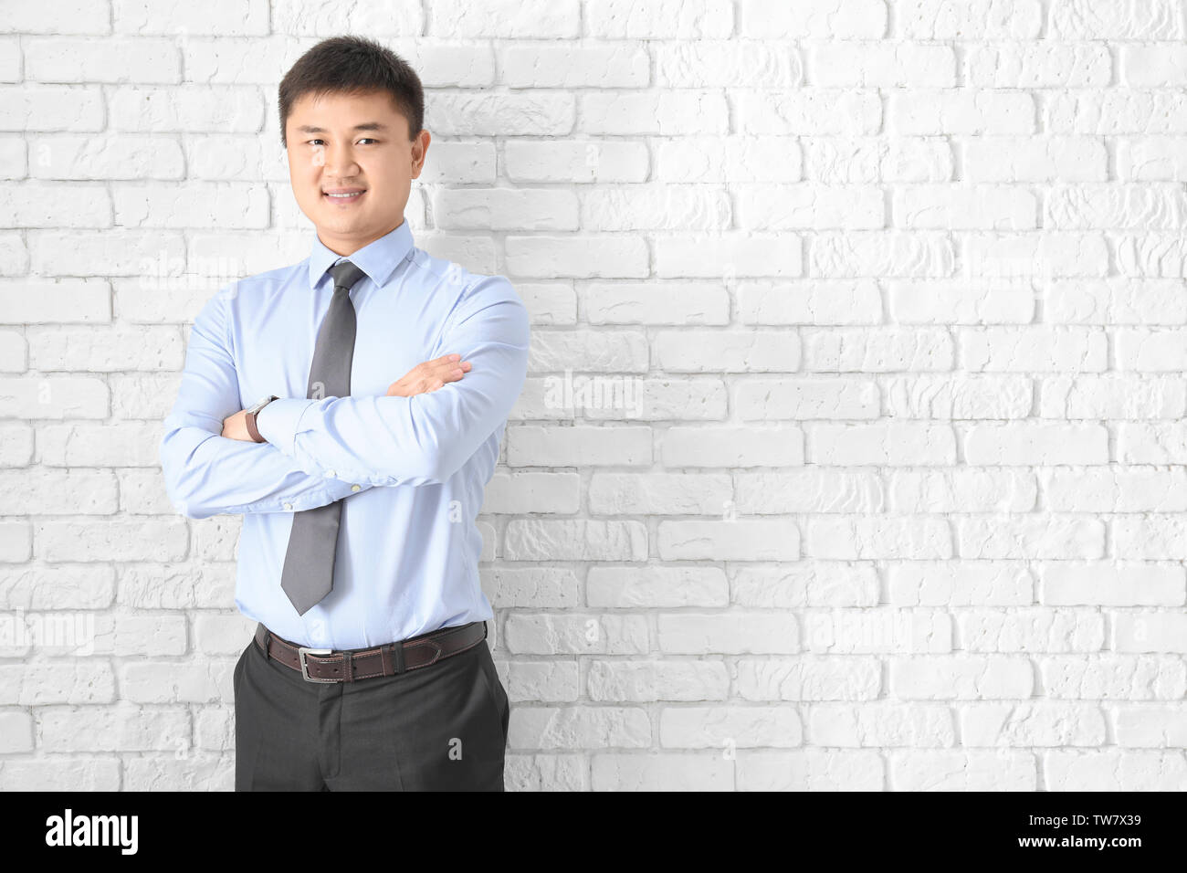 Young manager on brick wall background Stock Photo