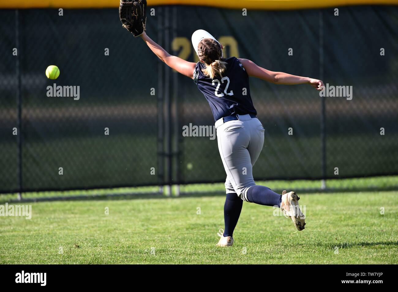 Center fielder unable to catch up with a drive over her head that resulted in a double. USA. Stock Photo