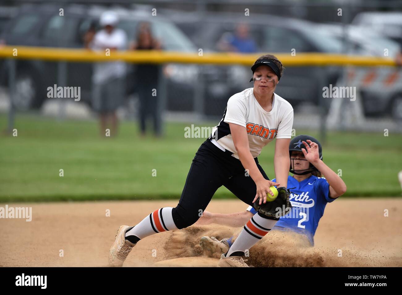 Batter/runner sliding in safely to second base with a double as an opposing infielder took a late throw at the bag. USA. Stock Photo
