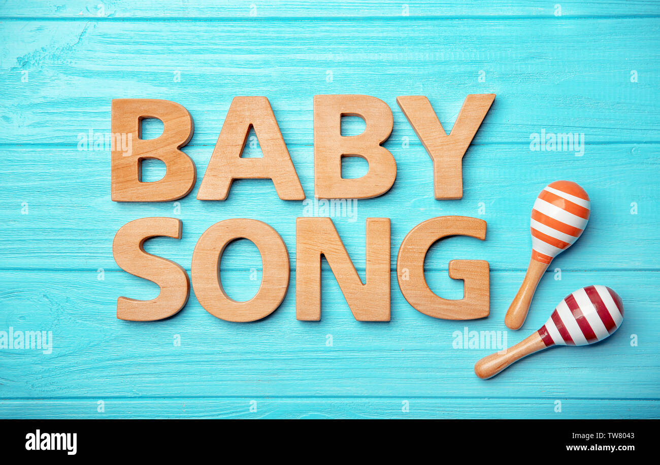 Text Baby Song And Toy Maracas On Wooden Background Stock Photo