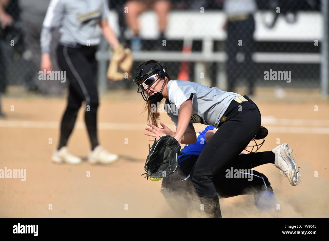 Infielder is unable to secure a throw from the outfield as opposing  runner was sliding safely into second base with a double. USA. Stock Photo