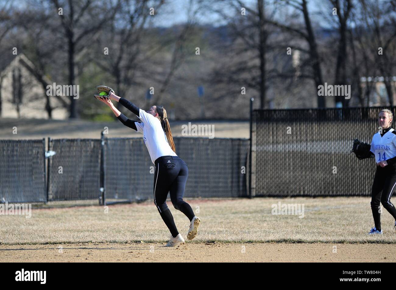 Shortstop making a running backhanded catch of a pop fly while running