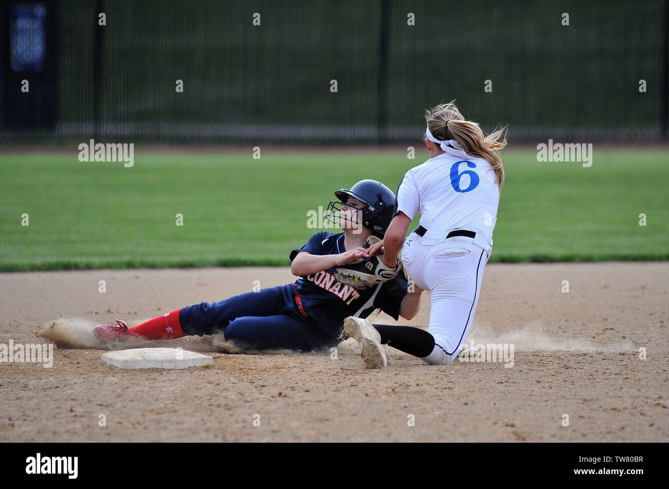 Middle infielder applying a tag on a sliding runner who was retired while attempting to steal second base. USA. Stock Photo