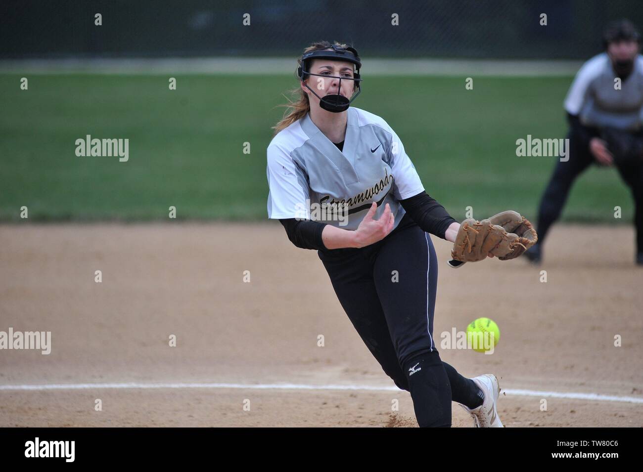 Pitcher in the circle releasing a pitch to a waiting opposing hitter ...